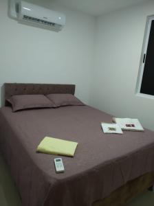 a bed with two cards and a yellow blanket on it at CAMINHOS do MAR ACOMODAÇÕES in Parnamirim +20 photos