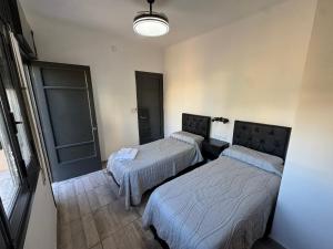 een kamer met 2 bedden en een licht bij Apart's Sobremonte - Deptos Modernos in Rio Cuarto