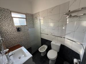 een badkamer met een wit toilet en een wastafel bij Apart's Sobremonte - Deptos Modernos in Rio Cuarto