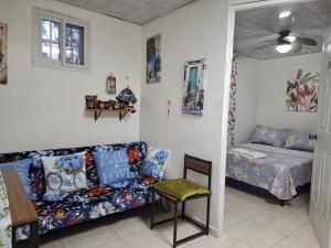 un soggiorno con un divano e un letto di Casa Lilia 10 minutos Aeropuerto Tocumen a Città di Panama