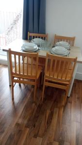 a dining room table with chairs and plates on it at City Sparrow - Upper Pad Nest in London