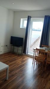 a living room with a table and chairs and a large window at City Sparrow - Upper Pad Nest in London