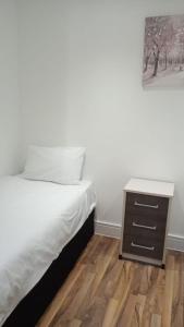 a bedroom with a bed and a night stand at City Sparrow - Upper Pad Nest in London