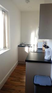a kitchen with a black counter top and a window at City Sparrow - Upper Pad Nest in London +7 photos