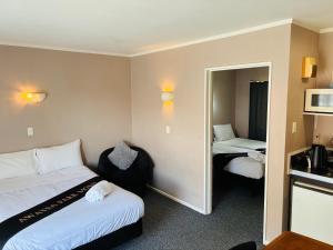 una camera d'albergo con due letti e uno specchio di Awatea Park Motel a Palmerston North
