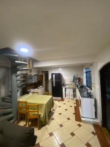 a kitchen with a table with a yellow table cloth at Espaço Sol in Peruíbe