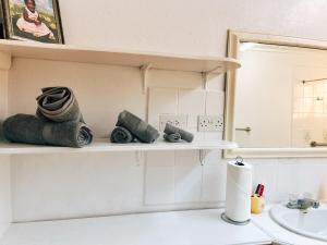 a bathroom with a sink and a shelf with towels at Krystal Apartment in Grande Rivière +14 photos