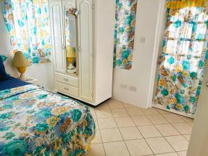 a bedroom with a bed and a dresser at Krystal Apartment in Grande Rivière
