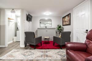 a living room with two chairs and a red rug at The Cozy Cottage in Waycross