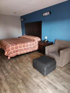 a hotel room with a bed and a chair at WESTERN MOTEl in Lucedale