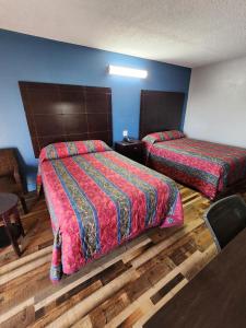 a hotel room with two beds and a table at WESTERN MOTEl in Lucedale