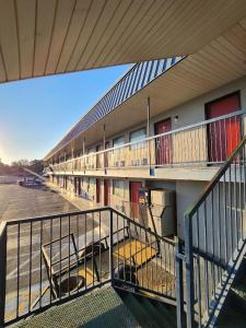 a building with a balcony with chairs in a parking lot at WESTERN MOTEl in Lucedale