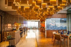 un ristorante con un grande lampadario a braccio, tavoli e sedie di Oakwood Hotel & Residence Sri Racha a Si Racha