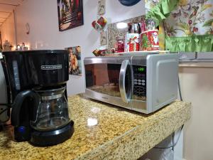 un forno a microonde appoggiato su un bancone accanto a una macchina per il caffè di Casa Lilia 10 minutos Aeropuerto Tocumen a Città di Panama