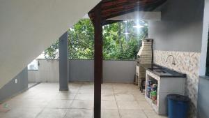 an outdoor patio with a stone fireplace in a house at Aconchego da Maria 2! in Mangaratiba