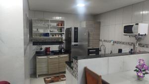 a kitchen with a stainless steel refrigerator and a tv at Aconchego da Maria 2! in Mangaratiba +3 photos