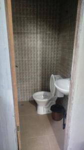 a bathroom with a toilet and a sink at Aconchego da Maria 2! in Mangaratiba