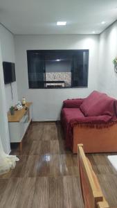 a bedroom with a bed and a television in it at Aconchego da Maria 2! in Mangaratiba