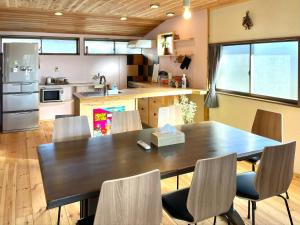 a kitchen with a large wooden table and chairs at 民泊Nao in Minami Alps
