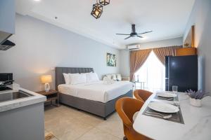 een slaapkamer met een bed en een tafel met stoelen bij Wyndham Garden Suites IPOH ICC in Ipoh