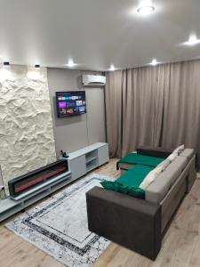 un soggiorno con divano e TV a schermo piatto di Сейфулина 31 a Balqash