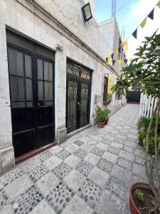een gebouw met zwarte deuren en een binnenplaats met planten bij Solar Vip Arequipa in Arequipa