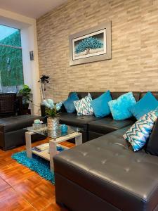 een woonkamer met een leren bank en blauwe kussens bij Solar Vip Arequipa in Arequipa