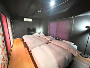 a room with four beds with pillows in it at Rino-Haku 03 in Anan