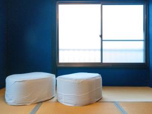 two white ottomans in a room with two windows at Rino-Haku 03 in Anan