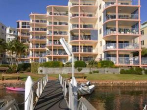 a row of boats sitting on top of a dock at On The River Apartments in Maroochydore