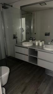 a bathroom with two sinks and a toilet and a mirror at Casa DOURO-PORTO in Valbom