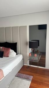 a bedroom with a bed and a table with a lamp at Casa DOURO-PORTO in Valbom
