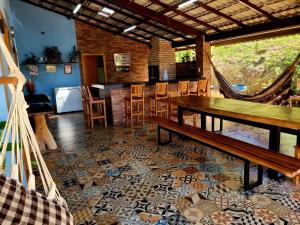 a room with a table and chairs and a kitchen at Rancho dos Ipês Corumbá in Alexânia