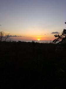 a sunset in a field with the sun in the sky at habitacion doble 1 Marcia place in San Andrés