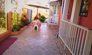 a table and an umbrella on a walk way at habitacion doble 1 Marcia place in San Andrés