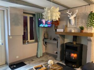 a living room with a fireplace and a tv at Au Pied de Troncais in Coust