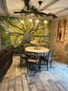 a dining room with a table and a tree mural at Au Pied de Troncais in Coust