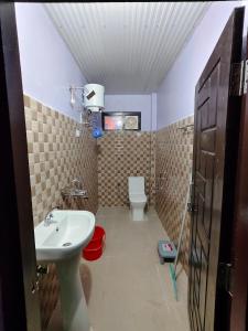 a small bathroom with a sink and a toilet at Bilju Homestay in Munsyari