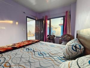 a bedroom with a large bed and two chairs at Bilju Homestay in Munsyari +10 photos