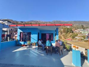 a group of people sitting at tables on the roof of a house at Bilju Homestay in Munsyari