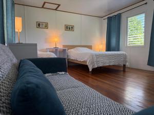 een woonkamer met twee bedden en een bank bij Horse Cottage in Sarteneja