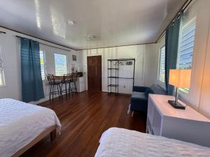 een slaapkamer met een bed, een bank en een tafel bij Horse Cottage in Sarteneja