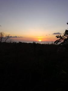 a sunset in a field with the sun setting at double room # 2 in San Andrés
