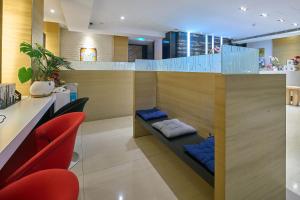 a lobby with red chairs and a bench with pillows at Golden Stone Hotel in Kaohsiung