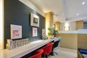 a library with red chairs and books on a counter at Golden Stone Hotel in Kaohsiung