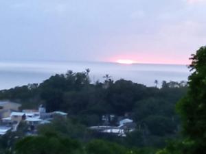 a sunset over the ocean with houses and trees at double room # 2 in San Andrés