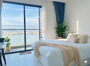 een slaapkamer met een bed en een groot raam bij BedKing Beverly VIP Luxury in Long Bình +15 foto's