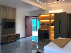 a bedroom with a bed and a tv in a room at Kalloos Island Backwater Resort in Kollam