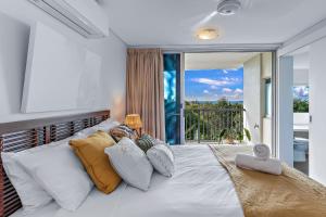 a bedroom with a large bed with a large window at Azure Sea Whitsunday Resort in Airlie Beach +215 photos