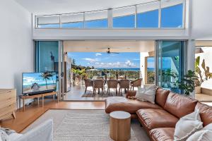 a living room with a couch and a television at Azure Sea Whitsunday Resort in Airlie Beach